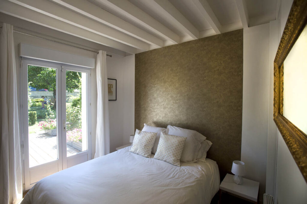 room with golden accents, beams, and a garden view